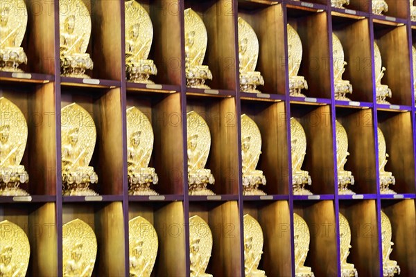 Jade Buddha temple, Shanghai, rows of small golden Buddha figures on shelves as wall decoration, Shanghai, China, Asia