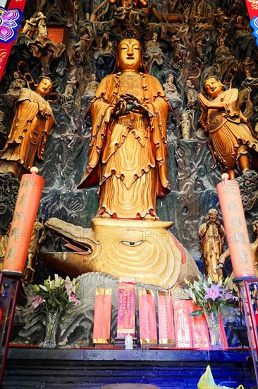 Jade Buddha Temple, Shanghai, Large gold-coloured statue in Asian style with red candles and flower offerings, Shanghai, China, Asia