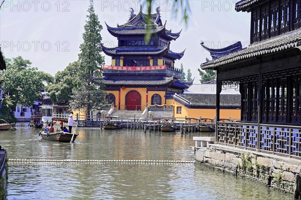 Excursion to Zhujiajiao Water Village, Shanghai, China, Asia, Traditional Chinese building with pagoda roof on a quiet water canal with a boat, Asia