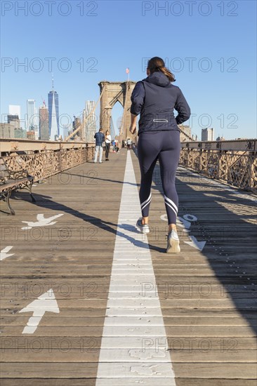 Jogger on the Brooklyn Bridge with Manhattan skyline, New York City, New York, USA, New York City, New York, USA, North America
