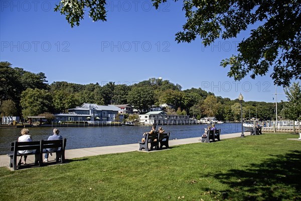 Saugatuck, Michigan, A town on the shore of Lake Michigan that thrives on tourism. The town has many art galleries, unique shops, and restaurants. People relax on benches along the Kalamazoo River