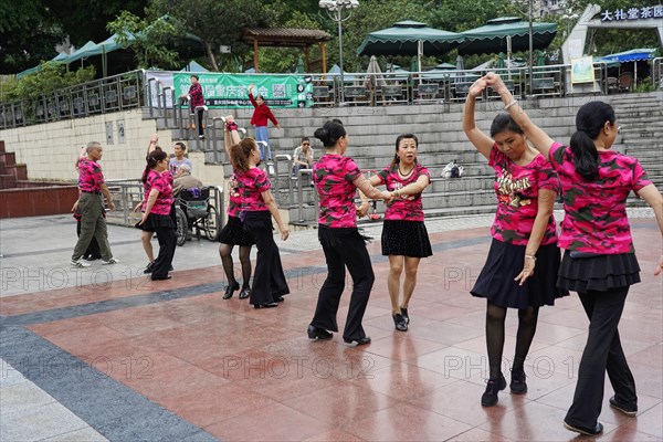 Residents of Chongqing dancing in the centre, Chongqing, China, Asia, People in pink shirts dancing in pairs in an outdoor square, Chongqing province, Asia