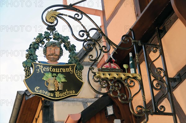 Eguisheim, Alsace, France, Europe, A creative pub sign for the Cadeau Bacchus restaurant with a wine motif, Europe