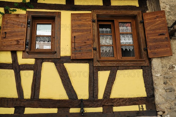 Eguisheim, Alsace, France, Europe, Traditional half-timbered house with wooden shutters and lace curtains, Europe