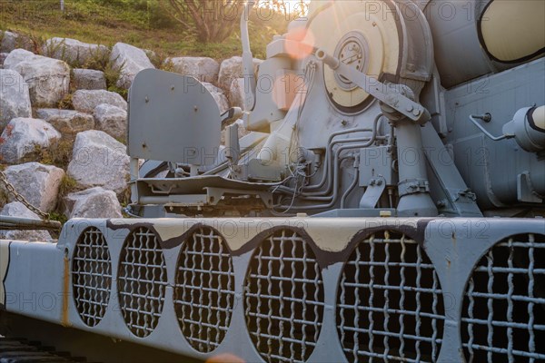 Side view of camouflaged army tank with vents above track and closeup view of chair on rear portion of vehicle in Nonsan, South Korea, Asia