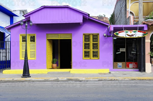 San Juan del Sur, Nicaragua, A vibrant purple house with yellow shutters and a colourful surfboard above, Central America, Central America