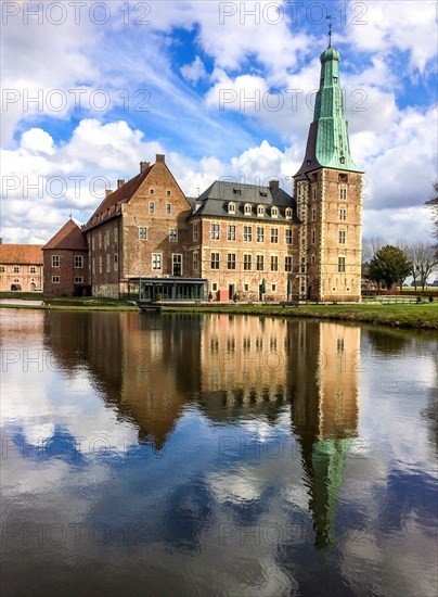 View over wide moat to historic moated castle from Renaissance Raesfeld Castle reflected in moat in spring, above clouds Altocumulus, excursion destination in North Rhine-Westphalia, Freiheit Raesfeld, Muensterland, North Rhine-Westphalia, Germany, Europe