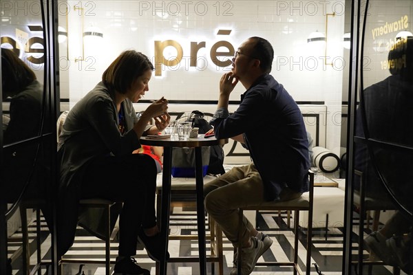 Evening stroll through Shanghai to the sights, Shanghai, A couple sits in a cafe chatting in a relaxed atmosphere in the evening, Shanghai, People's Republic of China