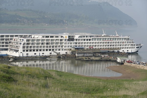Chongqing, Chongqing Province, Cruise ship on the Yangtze River, A luxury cruise ship at a dock in the middle of a hilly landscape, Chongqing, Chongqing Province, China, Asia