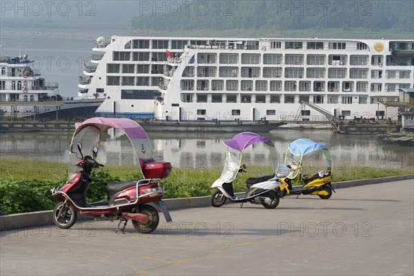 Chongqing, Chongqing Province, scooter with canopy on a riverside promenade, a cruise ship in the background, Yangtze River, Chongqing, Chongqing Province, China, Asia