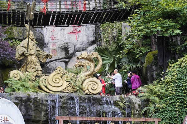 Chongqing, Chongqing Province, China, Asia, Sculpture of a dragon at an artificial waterfall, people watching, Asia