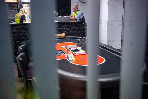View of a poker table through bars, monitored by security personnel, Cologne police led a raid against illegal gambling on Friday evening. Around 200 investigators from the police, customs, tax investigation, the public order office, the tax and revenue office, the immigration office and the public catering office were out on the streets of Cologne on Friday evening. They search 25 properties where there are indications that illegal gambling is taking place. And they make a find
