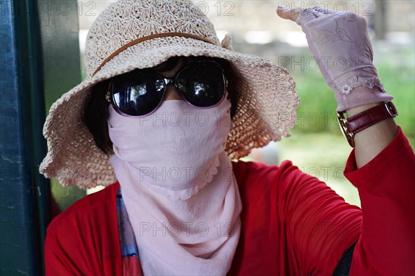 New Summer Palace, Beijing, China, Asia, A woman stylishly protects herself from the sun with a hat and scarf, Beijing, Asia