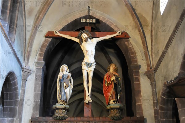Kaysersberg, Alsace Wine Route, Alsace, Departement Haut-Rhin, France, Europe, Crucifix between two religious statues in a church interior, Europe