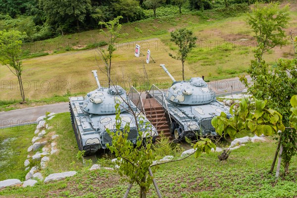 Military tanks with camouflage paint on display in public park near Nonsan, South Korea on overcast day