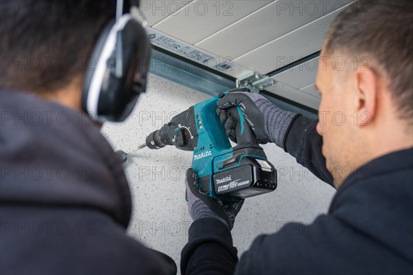 A focussed craftsman operates a drilling machine during interior work, solar systems construction, crafts, Muehlacker, Enzkreis, Germany, Europe