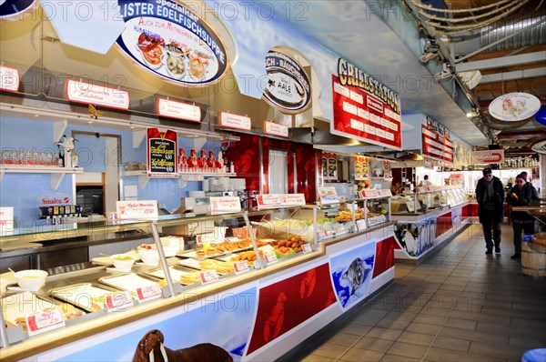 List, harbour, Sylt, North Frisian island, view into a hall with sales counters for fresh fish and seafood specialities, customers pass by, Sylt, Schleswig-Holstein, Germany, Europe