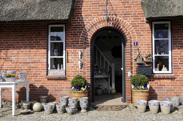House entrance, Keitum, Sylt, North Frisian Island, brick building with thatched roof and a decorative entrance door, surrounded by flower pots, Sylt, North Frisian Island, Schleswig Holstein, Germany, Europe