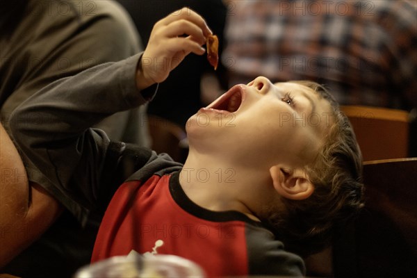 Denver, Colorado, Hendrix Hjermstad, 5, savors bacon at breakfast