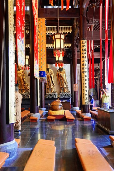 Jade Buddha Temple, Shanghai, Interior view of a temple with statues, wooden benches and red banners, Shanghai, China, Asia