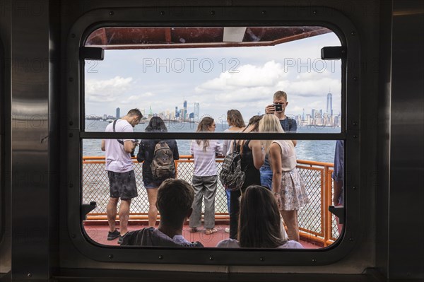 Tourists on the Staten Island ferry with a view of the Manhattan skyline, New York City, USA, New York City, New York, USA, North America