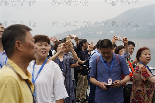 Cruise ship on the Yangtze River, Yichang, Hubei Province, China, Asia, A group of tourists taking photos on a foggy day on a riverbank, Asia