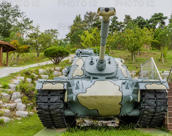 Front view of military tank with camouflage paint on display in public park in Nonsan, South Korea, Asia