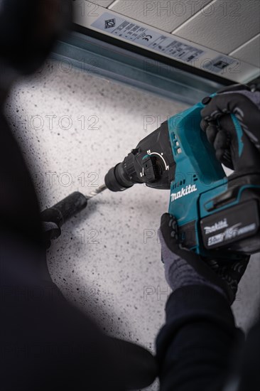 A person working with a Makita drilling machine on the ground, solar systems construction, trade, Muehlacker, Enzkreis, Germany, Europe