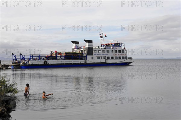 Ometepe Island, Nicaragua, A ferry with passengers sails near the shore with a mountainous background, Central America, Central America