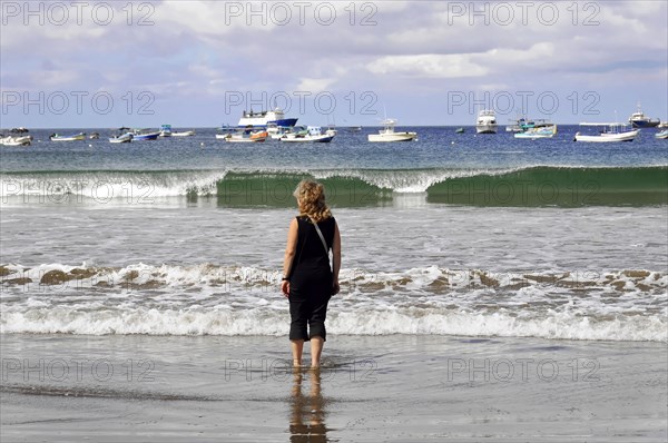 San Juan del Sur, Nicaragua, Woman on the beach looking at waves and boats, Reflections on the water, Central America, Central America