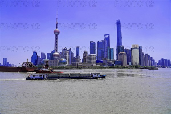 View from the Bund to the skyline at the Huangpu River with Oriental Pearl Tower, World Financial Centre, Shanghai Tower, Jin Mao-Building in the Pudong district, Shanghai, China, Asia, A river with skyline and ships under a bright blue sky, Asia