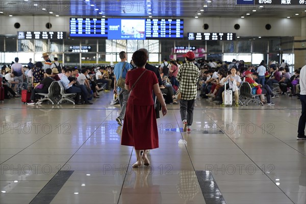 Hongqiao Railway Station, Shanghai, China, Asia, A person in red clothing walks through an airport waiting area, Yichang, Hubei Province, Asia