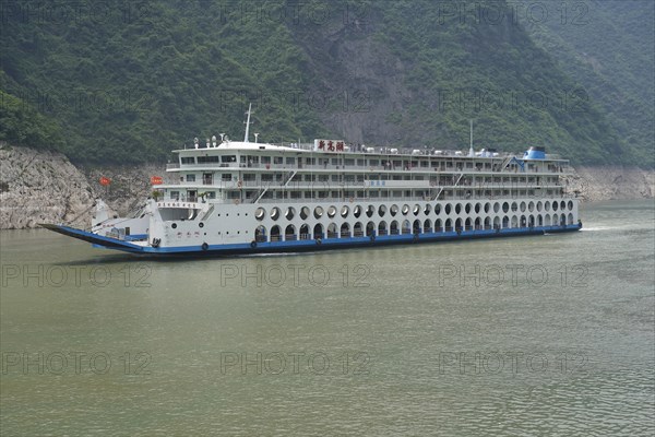 Chongqing, Chongqing Province, Cruise ship on the Yangtze River, A multi-storey cruise ship glides along a calm river with green surroundings, Yichang, Hubei Province, China, Asia