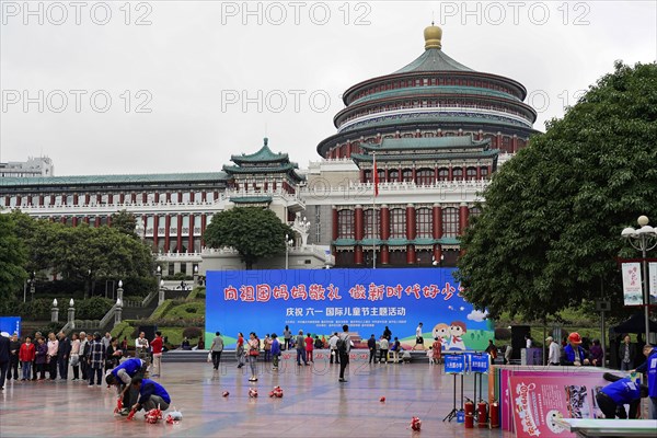Chongqing, Chongqing Province, China, Asia, People on a square with a prominent building in the background at a cultural event, Asia