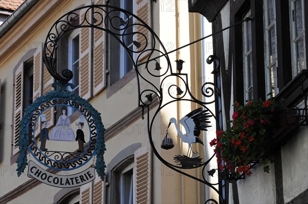 Kaysersberg, Alsace Wine Route, Alsace, Departement Haut-Rhin, France, Europe, Wrought-iron shop signs of a chocolaterie with floral decorations, Europe