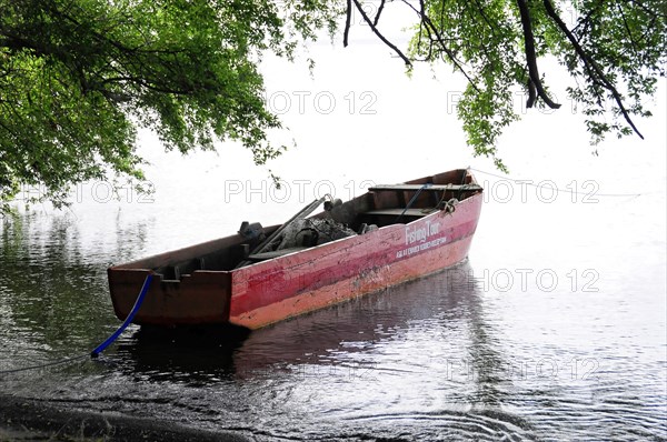 Ometepe Island, Nicaragua, Old rust-coloured rowing boat tied under hanging tree branches, Central America, Central America