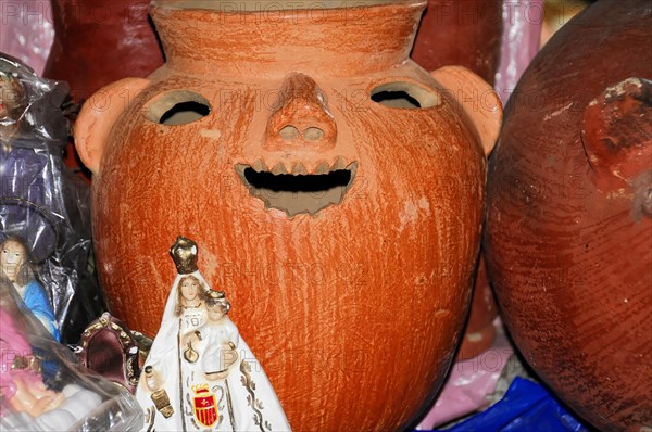 AUGUSTO C. SANDINO Airport, Managua, A red clay vessel with a carved face surrounded by other handicraft items, Nicaragua, Central America, Central America