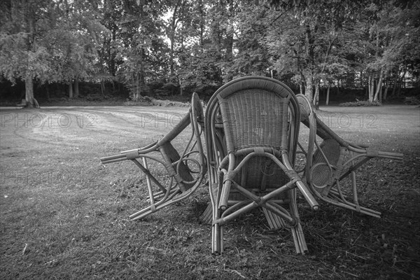 Four chairs are grouped around a table under a tree in a park, St George's Monastery, Isny im Allgaeu, Baden-Wuerttemberg, Germany, Europe