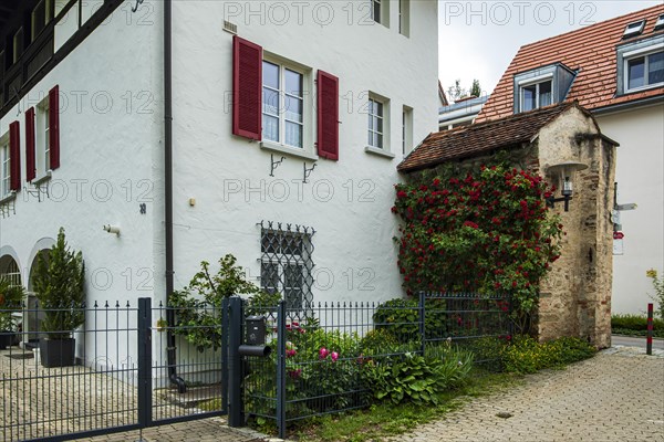 A section of the medieval town wall protrudes from a residential building, Old Town of Isny im Allgaeu, Baden-Wuerttemberg, Germany, Europe