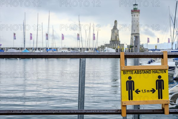 Advertising sign for physical distancing on the harbour railing in the old town of Lindau (Lake Constance), Bavaria, Germany, Europe