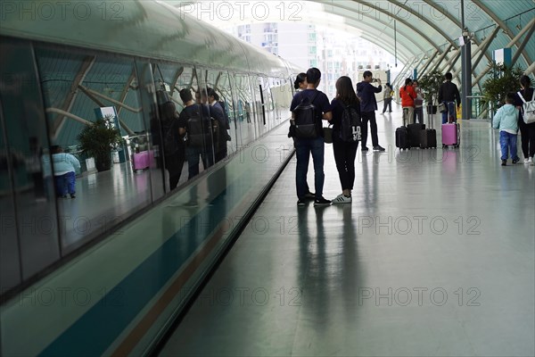 Shanghai Transrapid Maglev Shanghai Maglev Train Station Station, Shanghai, China, Asia, Travellers with luggage walk through a brightly lit glass tunnel, Asia