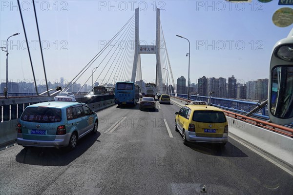 Traffic in Shanghai, Shanghai Shi, People's Republic of China, Traffic on a city bridge with skyscrapers in the background and bright sunlight, Shanghai, China, Asia