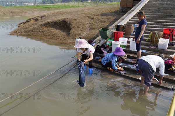 Women washing clothes in the Yangtze River, Yichang, Hubel Province, China, People washing clothes in the river, everyday scene with laundry and detergent on concrete steps, Yangtze River, Chongqing, Chongqing Province, China, Asia