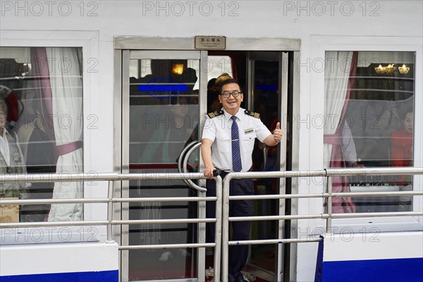 Chongqing, Chongqing Province, China, A ship officer in uniform smiles and greets friendly from a ship's door, Chongqing, Chongqing, Chongqing Province, China, Asia