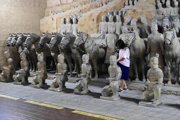 Figures of the terracotta army, Xian, Shaanxi Province, China, Asia, Visitor looking at the lined-up terracotta horses and warriors, Xian, Shaanxi Province, China, Asia