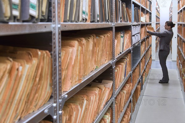 An employee of the Federal Commissioner for the Records of the State Security Service of the former German Democratic Republic, BStU, looks at Stasi files. Files and documents of the Ministry for State Security of the GDR are stored in the Stasi Records Authority, 17.01.2015., Berlin, Berlin, Germany, Europe