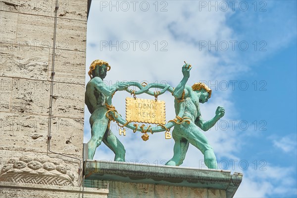 Golden biscuit with the 2 facade figures of the pretzel men on the Art Nouveau facade of the administration building of Bahlsen GmbH & Co. KG I Podbielskistrasse 11 in 30163 Hanover I Copyright: Carsten Milbret I, Hanover, Lower Saxony, Germany, Europe