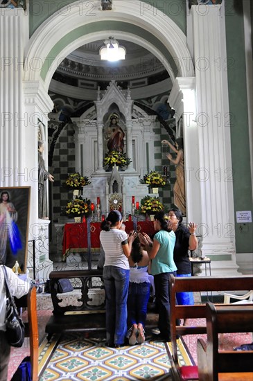 Church Iglesia de Guadalupe, built 1624 -1626, Granada, Nicaragua, Believers pray in a church with columns, statues and a colourful mosaic floor, Central America, Central America -, Central America