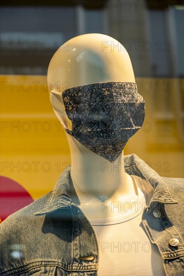 Mannequin with a corona mask on its face in a shop window of a fashion shop in the city centre of Weimar, Thuringia, Germany, Europe