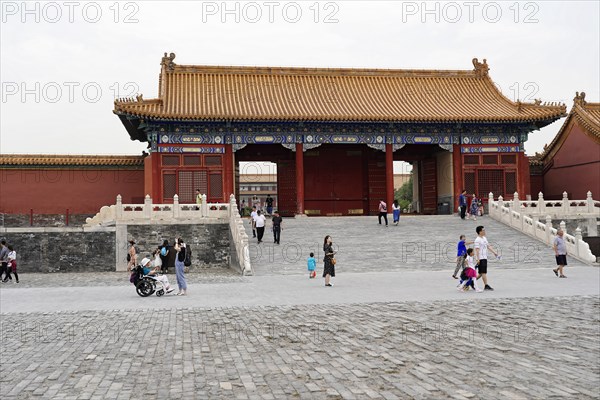 China, Beijing, Forbidden City, UNESCO World Heritage Site, tourists walk through one of the many gates of the Forbidden City with its impressive red walls, Asia